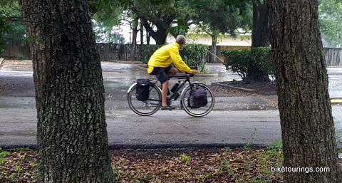 Picture of bike commuter riding touring bike with waterproof rain gear