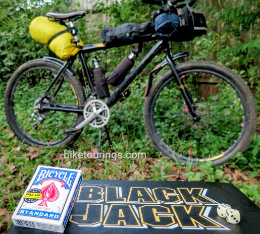 Picture of bicycle playing cards, black jack and dice with mountain bike for bicycle touring in background