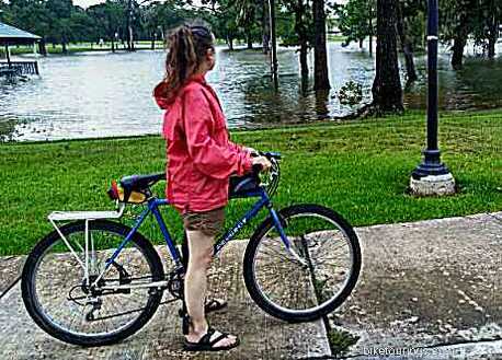 Picture of woman riding her touring bike with rain jacket