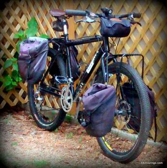 Picture of axiom front and rear panniers with with handlebar bag for bikepacking and bicycle touring
