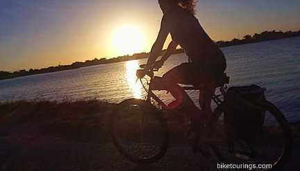 Picture of woman riding a touring bike at sunrise